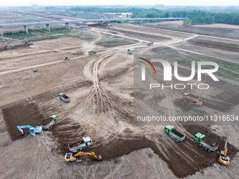 Workers are digging and cleaning the Huaihe River channel at the construction site of the second phase of the Huaihe River Waterway project...