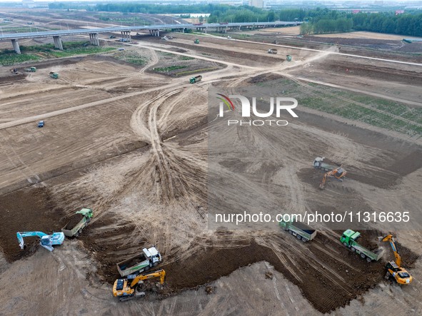 Workers are digging and cleaning the Huaihe River channel at the construction site of the second phase of the Huaihe River Waterway project...