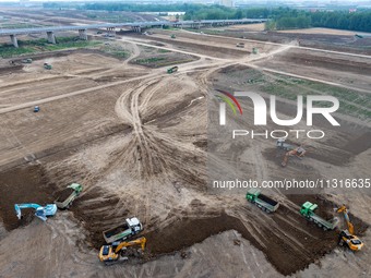 Workers are digging and cleaning the Huaihe River channel at the construction site of the second phase of the Huaihe River Waterway project...