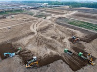 Workers are digging and cleaning the Huaihe River channel at the construction site of the second phase of the Huaihe River Waterway project...