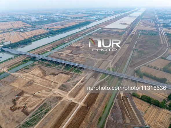 Workers are digging and cleaning the Huaihe River channel at the construction site of the second phase of the Huaihe River Waterway project...