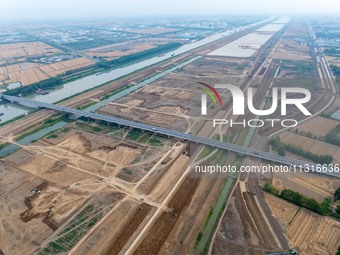 Workers are digging and cleaning the Huaihe River channel at the construction site of the second phase of the Huaihe River Waterway project...