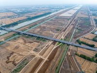 Workers are digging and cleaning the Huaihe River channel at the construction site of the second phase of the Huaihe River Waterway project...