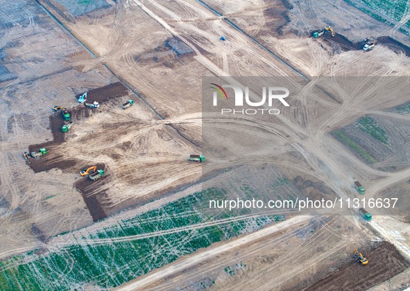 Workers are digging and cleaning the Huaihe River channel at the construction site of the second phase of the Huaihe River Waterway project...