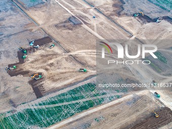 Workers are digging and cleaning the Huaihe River channel at the construction site of the second phase of the Huaihe River Waterway project...