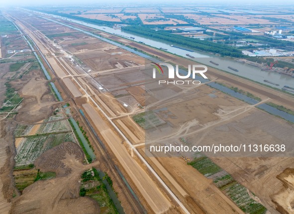 Workers are digging and cleaning the Huaihe River channel at the construction site of the second phase of the Huaihe River Waterway project...