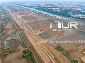 Workers are digging and cleaning the Huaihe River channel at the construction site of the second phase of the Huaihe River Waterway project...