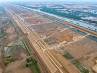 Workers are digging and cleaning the Huaihe River channel at the construction site of the second phase of the Huaihe River Waterway project...