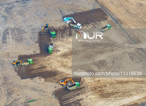 Workers are digging and cleaning the Huaihe River channel at the construction site of the second phase of the Huaihe River Waterway project...