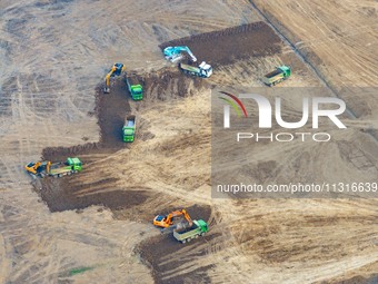 Workers are digging and cleaning the Huaihe River channel at the construction site of the second phase of the Huaihe River Waterway project...