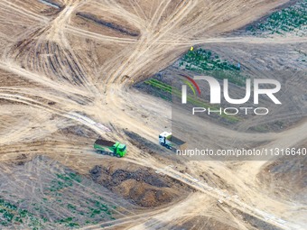 Workers are digging and cleaning the Huaihe River channel at the construction site of the second phase of the Huaihe River Waterway project...