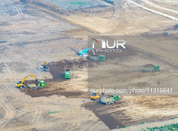 Workers are digging and cleaning the Huaihe River channel at the construction site of the second phase of the Huaihe River Waterway project...