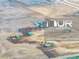 Workers are digging and cleaning the Huaihe River channel at the construction site of the second phase of the Huaihe River Waterway project...