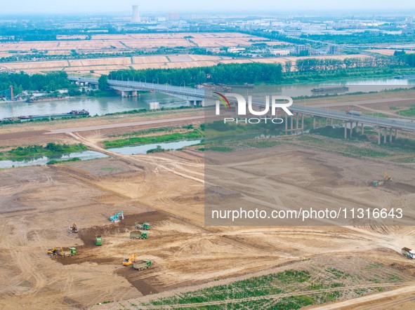 Workers are digging and cleaning the Huaihe River channel at the construction site of the second phase of the Huaihe River Waterway project...