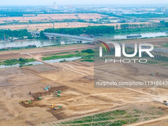 Workers are digging and cleaning the Huaihe River channel at the construction site of the second phase of the Huaihe River Waterway project...