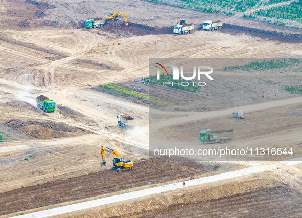 Workers are digging and cleaning the Huaihe River channel at the construction site of the second phase of the Huaihe River Waterway project...