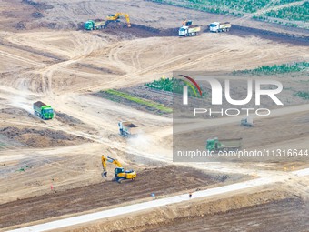 Workers are digging and cleaning the Huaihe River channel at the construction site of the second phase of the Huaihe River Waterway project...