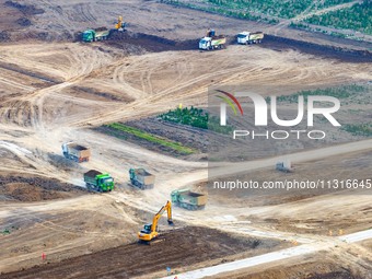 Workers are digging and cleaning the Huaihe River channel at the construction site of the second phase of the Huaihe River Waterway project...