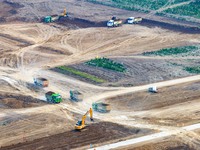 Workers are digging and cleaning the Huaihe River channel at the construction site of the second phase of the Huaihe River Waterway project...