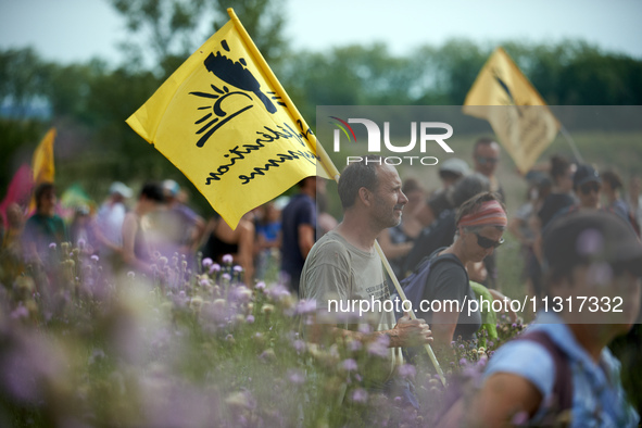 A member of the farmers' union Confederation Paysanne is holding a flag of the union. Nearly 5,000 people are participating in a weekend of...