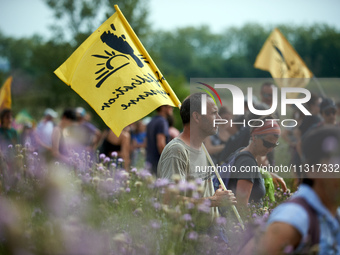 A member of the farmers' union Confederation Paysanne is holding a flag of the union. Nearly 5,000 people are participating in a weekend of...