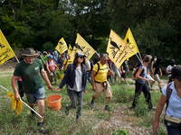 Protesters and members of the farmers' union, Confederation Paysanne, are walking in a field that will be destroyed by the building of the A...