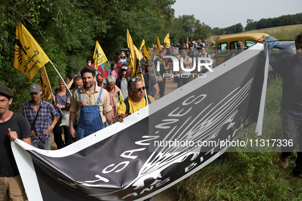 Protesters and members of the farmers' union, Confederation Paysanne, are walking towards the field which will be destroyed by the building...