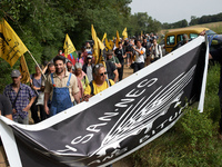 Protesters and members of the farmers' union, Confederation Paysanne, are walking towards the field which will be destroyed by the building...