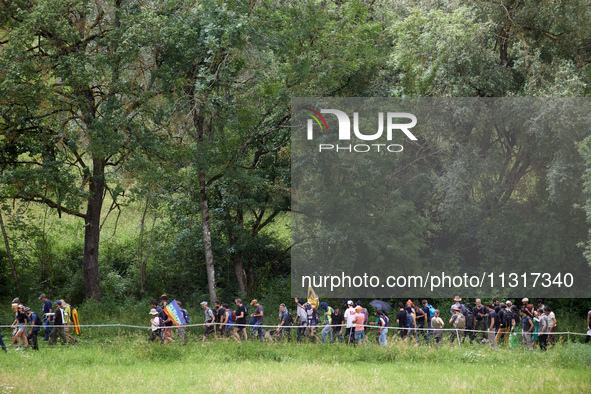 Protesters are walking near a wood. Nearly 5,000 people are participating in a weekend of action called 'Roue Libre' in the Tarn department...