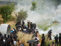 The black bloc is confronting riot police amid clouds of tear gas. Nearly 5,000 people are participating in a weekend of action called 'Roue...