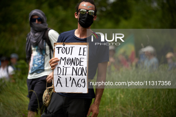 A protester is holding a placard reading 'Everyone says no to the A69'. Nearly 5,000 people are participating in a weekend of action called...