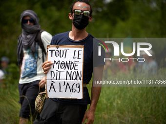 A protester is holding a placard reading 'Everyone says no to the A69'. Nearly 5,000 people are participating in a weekend of action called...