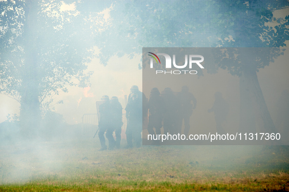 Riot policemen are standing amid clouds of tear gas. Nearly 5,000 people are participating in a weekend of action called 'Roue Libre' in the...