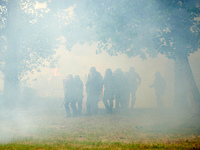 Riot policemen are standing amid clouds of tear gas. Nearly 5,000 people are participating in a weekend of action called 'Roue Libre' in the...