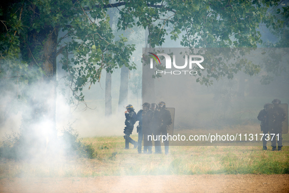 Riot policemen are standing amid clouds of tear gas. Nearly 5,000 people are participating in a weekend of action called 'Roue Libre' in the...