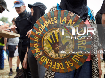 The shield is reading 'We are the nature which defends itself', the motto of the 'soulevements de la Terre' (i.e., 'Earth uprising'). Nearly...