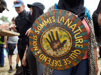 The shield is reading 'We are the nature which defends itself', the motto of the 'soulevements de la Terre' (i.e., 'Earth uprising'). Nearly...