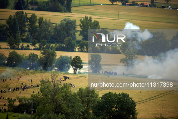 Black bloc is confronting riot police in a field during the protest. Nearly 5,000 people are participating in a weekend of action called 'Ro...