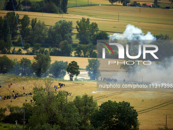 Black bloc is confronting riot police in a field during the protest. Nearly 5,000 people are participating in a weekend of action called 'Ro...