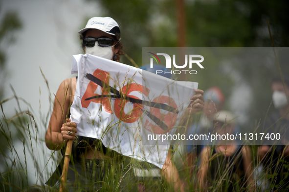 A protester is holding a flag against the A69 highway. Nearly 5,000 people are participating in a weekend of action called 'Roue Libre' in t...