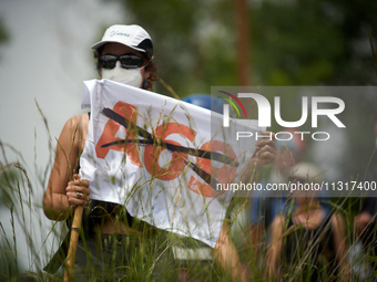 A protester is holding a flag against the A69 highway. Nearly 5,000 people are participating in a weekend of action called 'Roue Libre' in t...