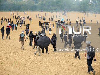 Black bloc is standing in a field during skirmishes with riot police. Nearly 5,000 people are participating in a weekend of action called 'R...