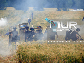 Black bloc is standing in a field of wheat during skirmishes with riot police. Nearly 5,000 people are participating in a weekend of action...