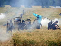 Black bloc is standing in a field of wheat during skirmishes with riot police. Nearly 5,000 people are participating in a weekend of action...