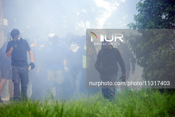 A black bloc is moving amid clouds of tear gas. Nearly 5,000 people are participating in a weekend of action called 'Roue Libre' in the Tarn...