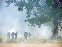 Riot policemen are standing amid clouds of tear gas. Nearly 5,000 people are participating in a weekend of action called 'Roue Libre' in the...