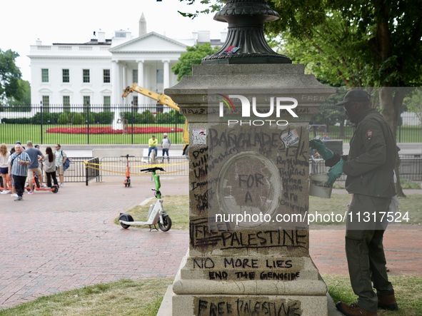 Work crews remove fences and clean statues that were covered in graffiti following a Gaza protest at the White House, in Washington, United...