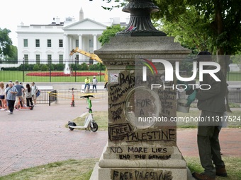 Work crews remove fences and clean statues that were covered in graffiti following a Gaza protest at the White House, in Washington, United...