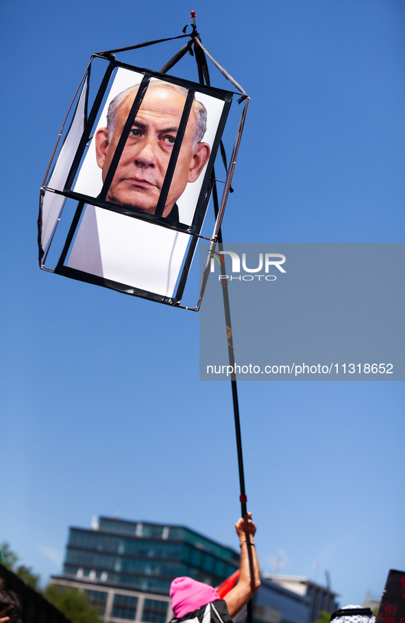 A demonstrator carries a rendition of Israeli Prime Minister Benjamin Netanyahu behind bars during a protest at the White House, Washington,...