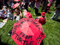 Two people take shelter from the sun under an umbrella during a pro-Palestinian protest at the White House, Washington, DC, June 8, 2024....